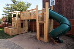 a wooden play set with a green slide