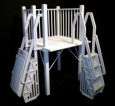 a white chair sitting on top of a black floor next to a set of stairs