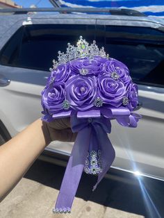 a bouquet of purple roses is being held in front of a silver car with the sun shining on it