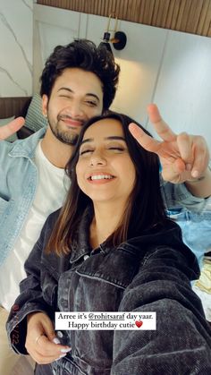 two people are smiling and making the peace sign