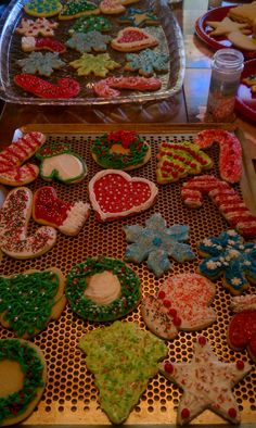 many decorated cookies are on a cooling rack