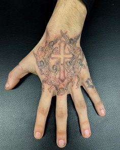 a man's hand with a cross tattoo on it