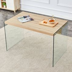 a glass table with a bowl of oranges on it and a magazine next to it