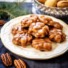 a white plate topped with caramel pretzels next to a bowl of pecans