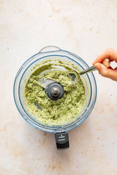 someone is mixing pest in a food processor