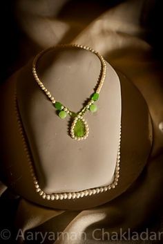 a necklace with green beads is on display