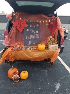 the back end of a car with decorations on it and a sign that says are you halloween jesus