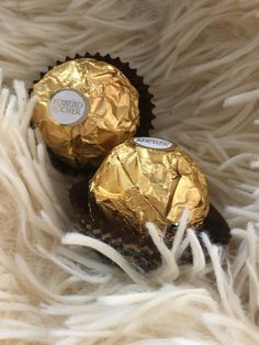 two chocolate covered candies sitting on top of a white furnishing area next to each other