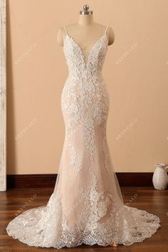 a wedding dress on display in front of a mannequin with an open back