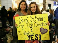 two girls holding up a sign that says skip school for one direction i think yes