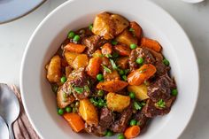 a white bowl filled with meat and vegetables