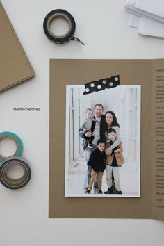 an open book with two photos and some scissors on the table next to it is a pair of black eyeglasses