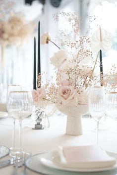 a white table topped with lots of flowers and candles