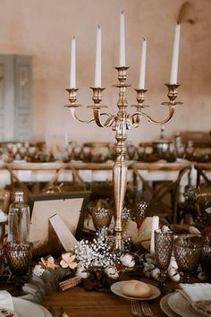 an elegant table setting with candles and plates