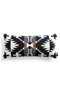 a black and white pillow with an orange design on the front, sitting against a white background