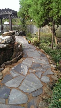 a stone path in the middle of a garden