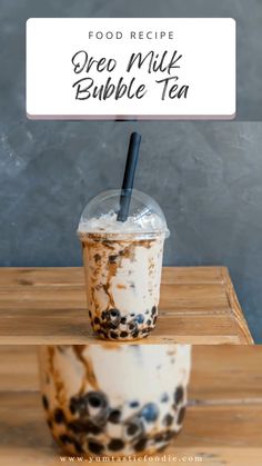 a cup with a straw in it sitting on top of a table next to a sign that says, food recipe oreo milk bubble tea