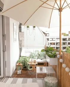 an outdoor patio area with white furniture and plants on the table, next to a wooden fence