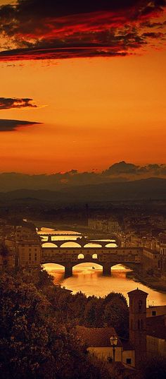 an orange sunset over a city with bridges