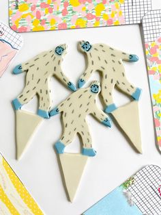 three white and blue decorated cookies sitting on top of a table next to other items