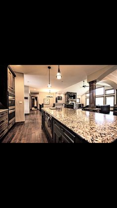 a large kitchen with marble counter tops and wooden cabinets