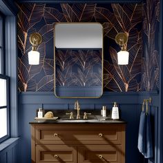 a bathroom with blue walls, gold fixtures and palm leaves on the wall behind the sink