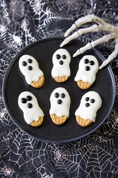 halloween treats on a black plate with white icing and spooky eyes for decoration