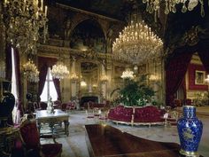 an ornately decorated room with chandeliers and couches