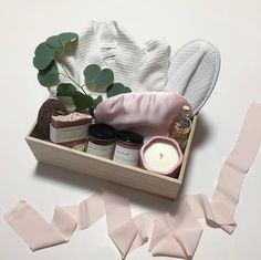 a wooden box filled with items on top of a white table next to pink tape