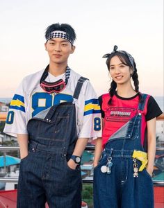 two people standing next to each other wearing overalls