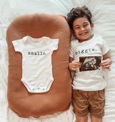 a little boy that is laying down next to a pillow