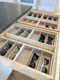 an open drawer with several pairs of sunglasses in it