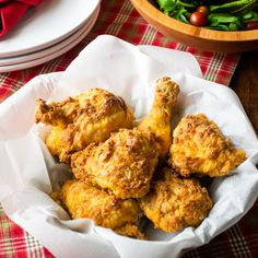 some fried chicken in a basket on a table