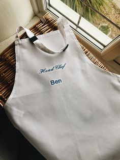 a white apron sitting on top of a table next to a window