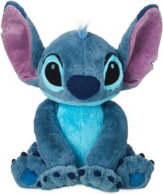 a blue stuffed animal with big ears sitting on the ground and looking at the camera