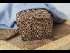 a loaf of bread sitting on top of a cutting board next to a blue towel