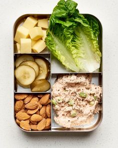 a bento box filled with different types of food and veggies on it