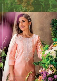 a woman wearing a pink outfit with flowers in the background