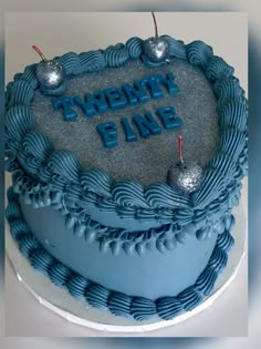 a blue frosted birthday cake with the words twenty five and two cherries on top