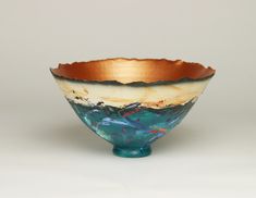 a blue and gold bowl sitting on top of a white table