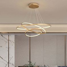 a modern chandelier hanging from the ceiling in a living room with marble walls and flooring