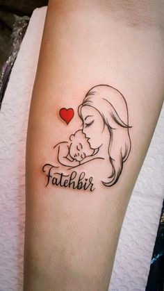 a woman with a tattoo on her arm holding a baby