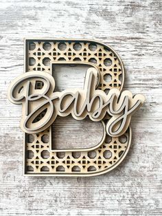 the letter b is made out of wood and has laser cutouts on it to spell baby's name