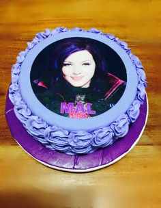 a blue cake with a picture of a woman on the top and purple icing