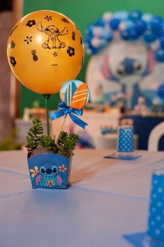 a balloon is sitting on top of a potted plant in the middle of a table