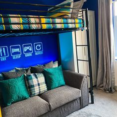 a bunk bed is in the middle of a room with blue walls and curtains on it