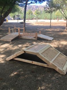 three wooden ramps sitting on top of a dirt field