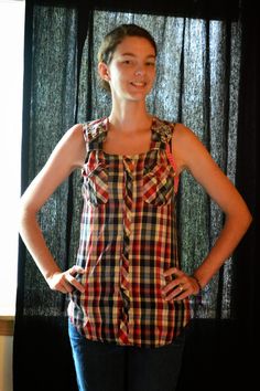 a woman standing in front of a black curtain with her hands on her hips and smiling at the camera