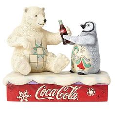 a polar bear and penguin sitting on top of a coca - cola box with a bottle