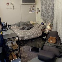 a room with a bed, couch and table in it that has a teddy bear sitting on the chair